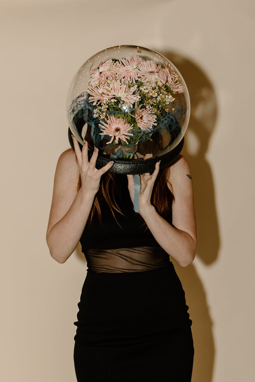 woman in black tank top and black skirt holding desk globe